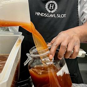 Hjemmelavet saft hældes på glas på Hindsgavl Slot i Middelfart